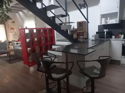 a kitchen with two chairs and a counter with a staircase at House in Sant Cugat, 25 Mins to Barcelona center in Sant Cugat del Vallès