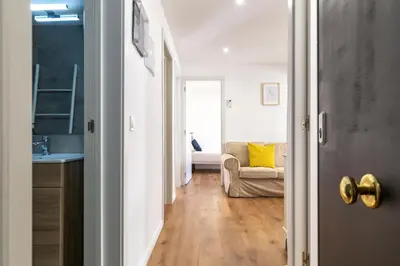 a hallway leading to a living room with a couch at Picasso Suites Cornellá in Cornellà de Llobregat