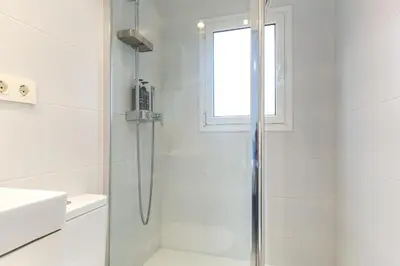 a white bathroom with a shower and a sink at Picasso Suites Cornellá in Cornellà de Llobregat