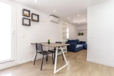 a dining room and living room with a table and chairs at Picasso Suites Cornellá in Cornellà de Llobregat