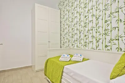 a room with a bed and a green and white wallpaper at Alcam Baro 22 in Barcelona