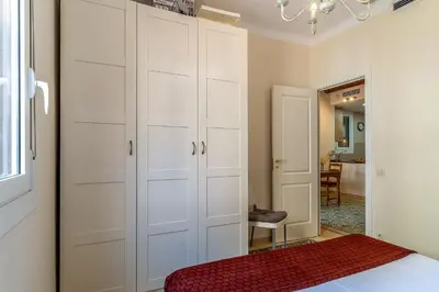 a bedroom with white cabinets and a red rug at 2098 - AB Sagrada Família Bofill in Barcelona