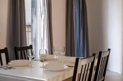 a white table with glasses and plates on it at StayCampNou 3BR With Balcony in Hospitalet de Llobregat