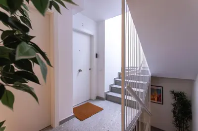 a hallway with stairs and a white door at StayCampNou 3BR With Balcony in Hospitalet de Llobregat