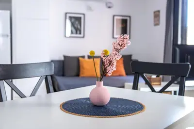a pink vase on a table with flowers in it at StayCampNou 3BR With Balcony in Hospitalet de Llobregat