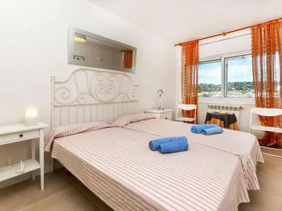 a bedroom with two beds with blue pillows on them at Apartment Cortijo Barques by Interhome in Sitges