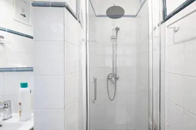 a white bathroom with a shower with a glass door at Apartamento Luna in Montgat