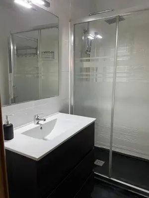 a bathroom with a white sink and a shower at Apartamento Villa Caracol in Cunit