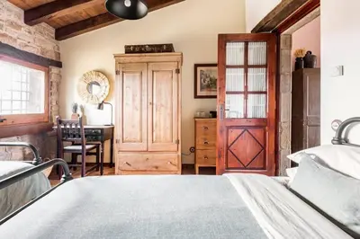 a bedroom with a bed and a wooden door at Masía espectacular cerca de Barcelona in Granera