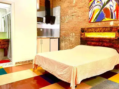 a bedroom with a bed in a room with a brick wall at Estudio nuevo! Al lado del metro L1 L4 L5 in Barcelona