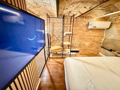 a room with a bed and a chair in a room at Estudio nuevo! Al lado del metro L1 L4 L5 in Barcelona
