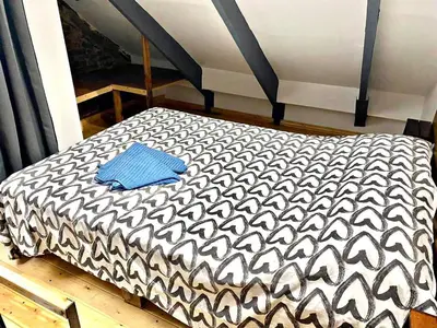 a black and white bed with a blue towel on it at Estudio nuevo! Al lado del metro L1 L4 L5 in Barcelona