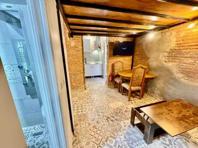 a dining room with a table and a brick wall at Estudio nuevo! Al lado del metro L1 L4 L5 in Barcelona