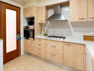 a kitchen with wooden cabinets and a stove top oven at Niu d'Oreneta in Canet de Mar