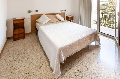 a bedroom with a bed and a dresser and a window at Niu d'Oreneta in Canet de Mar
