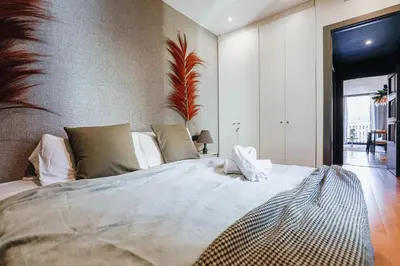 a bedroom with a large bed with white pillows at En Ville Boutique Apartments Tamarit in Barcelona