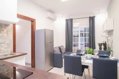 a kitchen and living room with a refrigerator and a table at Dega Sagrada Familia in Barcelona