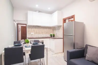 a kitchen with a table with chairs and a refrigerator at Dega Sagrada Familia in Barcelona