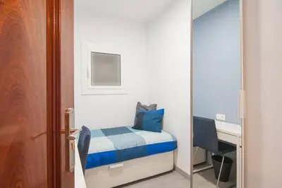 a bedroom with a bed and a desk and a mirror at Dega Sagrada Familia in Barcelona