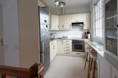 a kitchen with white cabinets and a stainless steel refrigerator at Lovely house in Bellaterra (10 min to UAB) in Cerdanyola del Valles