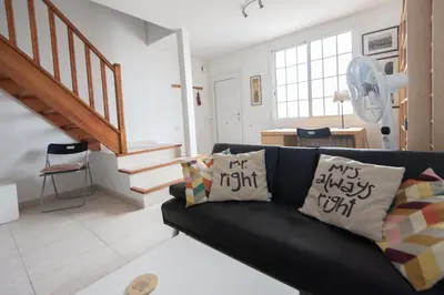 a living room with a black couch with pillows on it at Lovely house in Bellaterra (10 min to UAB) in Cerdanyola del Valles