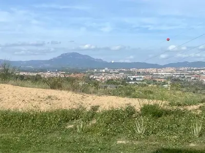 a view of a city from a field with a kite in the sky at Lovely house in Bellaterra (10 min to UAB) in Cerdanyola del Valles