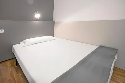a large white bed in a small room at Sant Jordi Apartments Sagrada Familia in Barcelona