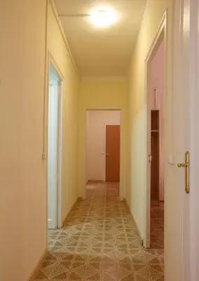 an empty hallway with yellow walls and an open door at Apartamentos Olivier in Barcelona