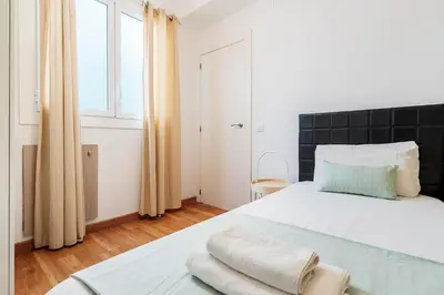 a bedroom with a large white bed and a window at Sunny 3BR for 4 Iconic Terrace Views in Barcelona
