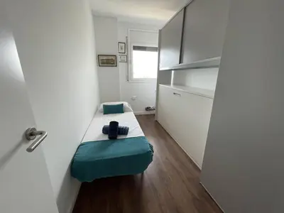 a small room with a small bed with a green pillow at Rengle Horizonte Penthouse & Pool in Mataró