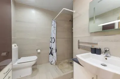 a bathroom with a white toilet and a sink at Matarolux27 in Mataró