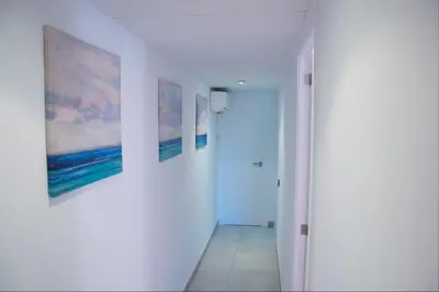 a hallway with two paintings on the wall and a door at Apartment Sagrera in Barcelona