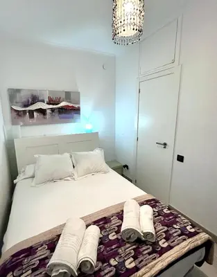 a bedroom with a bed with towels and a chandelier at Apartment Sagrera in Barcelona