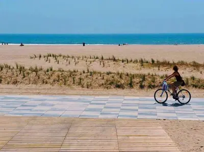 a boy riding a bike on the beach at Apartamento en la playa de Castelldefels ( Barcelona) in Castelldefels