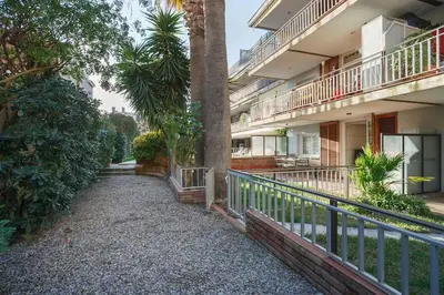 a building with a balcony with a fence and trees at Apartamento en la playa de Castelldefels ( Barcelona) in Castelldefels