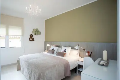 a bedroom with a white bed and a chandelier at Charming & Quiet Park Guell Apartment in Barcelona