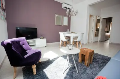 a living room with a purple chair and a table at Charming & Quiet Park Guell Apartment in Barcelona