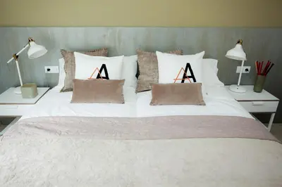 a white bed with two pillows and two lamps at Charming & Quiet Park Guell Apartment in Barcelona