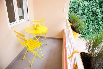 a small yellow table and chairs on a balcony at Charming & Quiet Park Guell Apartment in Barcelona