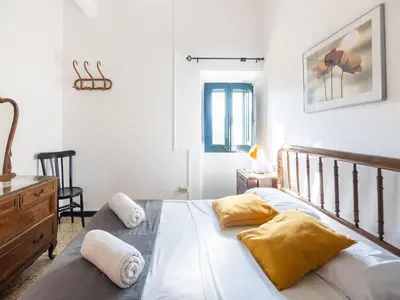 a bedroom with a bed with yellow pillows on it at Can Teulera in San Martín Sarroca
