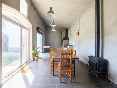 a dining room with a table and a stove at Can Teulera in San Martín Sarroca