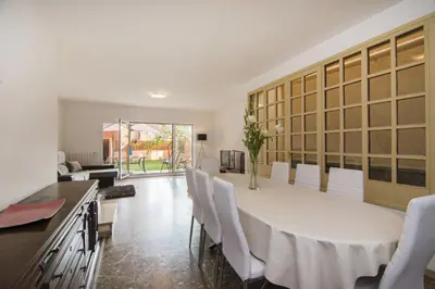 a dining room with a white table and white chairs at Holiday home Splendid Park Güell in Barcelona