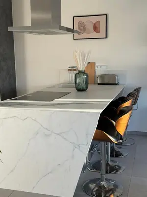 a kitchen with a counter with two stools at Shome in Vilanova i la Geltrú