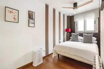 a bedroom with a bed and a ceiling fan at ArtlifeBCN Fira Apartment in Barcelona