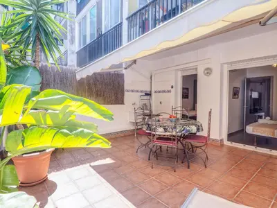 a patio with a table and chairs in a building at Zafiro Apartment by Hello Homes Sitges in Sitges