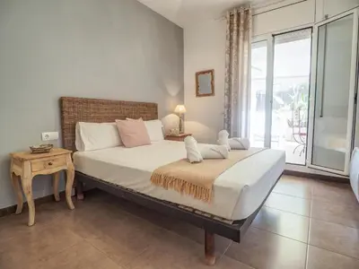 a bedroom with a large bed and a large window at Zafiro Apartment by Hello Homes Sitges in Sitges