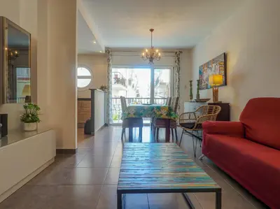 a living room with a red couch and a table at Zafiro Apartment by Hello Homes Sitges in Sitges