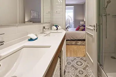 a bathroom with two sinks and a shower at Habitat Apartments Barcelona Plaza in Barcelona