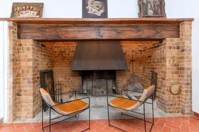 a brick fireplace with two chairs in front of it at La Terraza - Großzügiges Appartment in Katalanischer Masia in Sant Iscle de Vallalta
