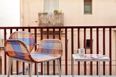 a wicker chair and a table with a cup of coffee at Maria Poblenou Apartment by Olala Homes in Barcelona